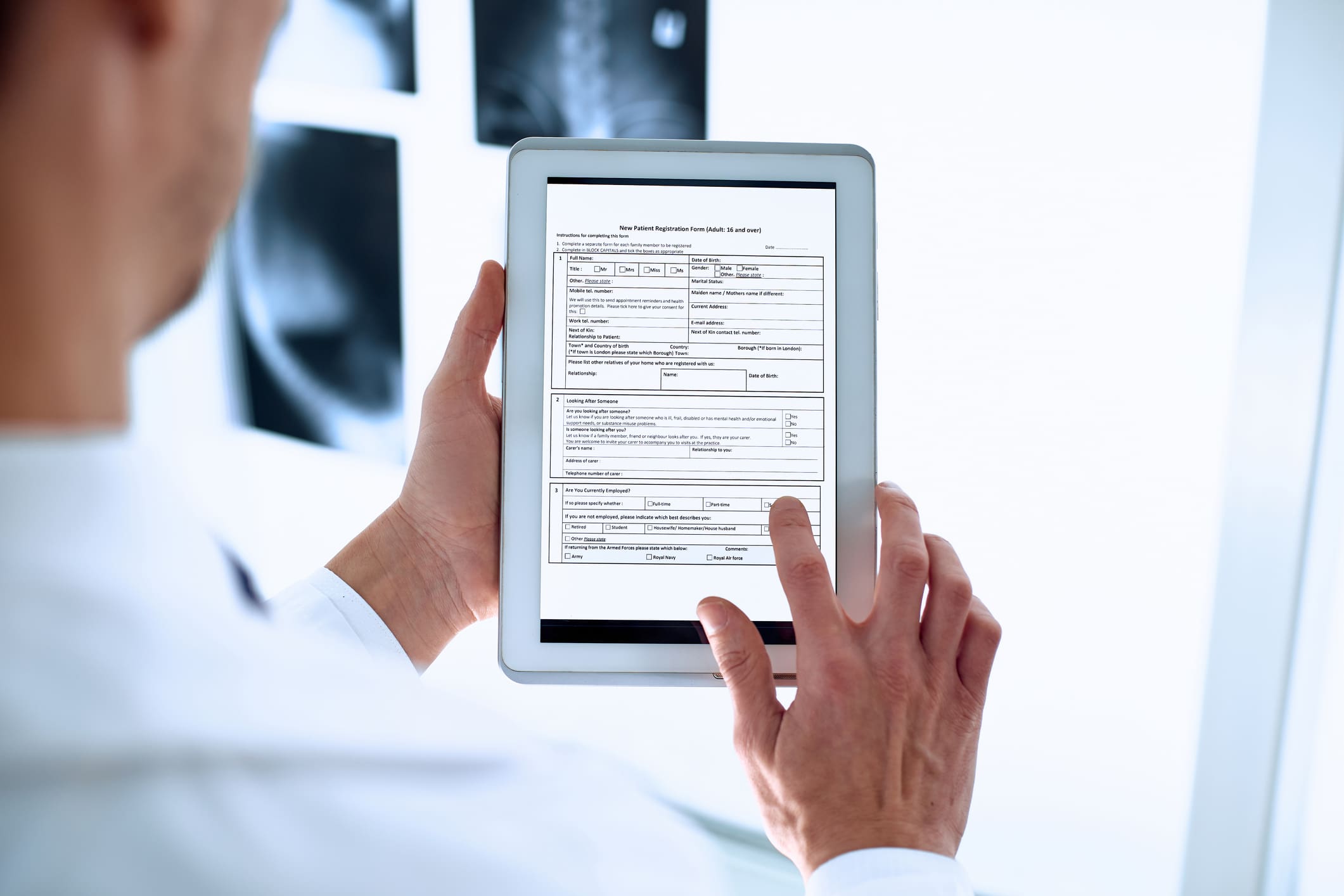 doctor is using a digital tablet to fill out the registration form doctor is using a digital tablet to fill out the registration form